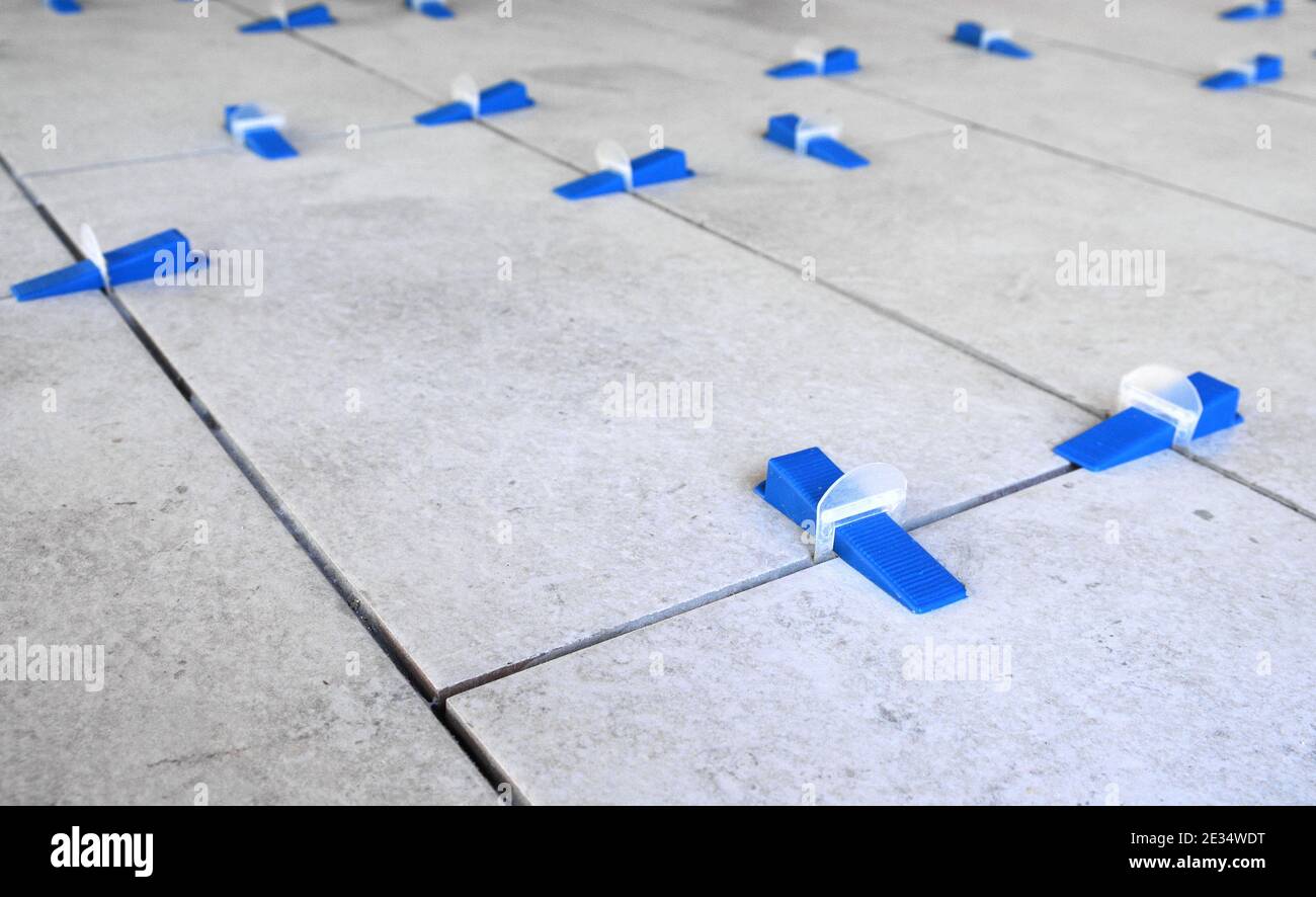 Industrial background. Tile leveling system with plastic clips and wedges, Stock Photo