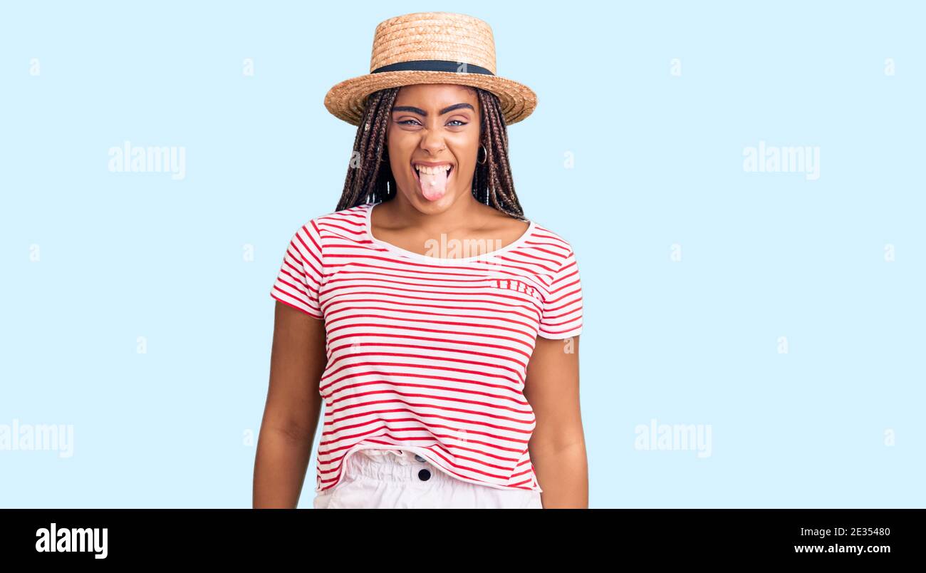 Young african american woman with braids wearing summer hat sticking ...