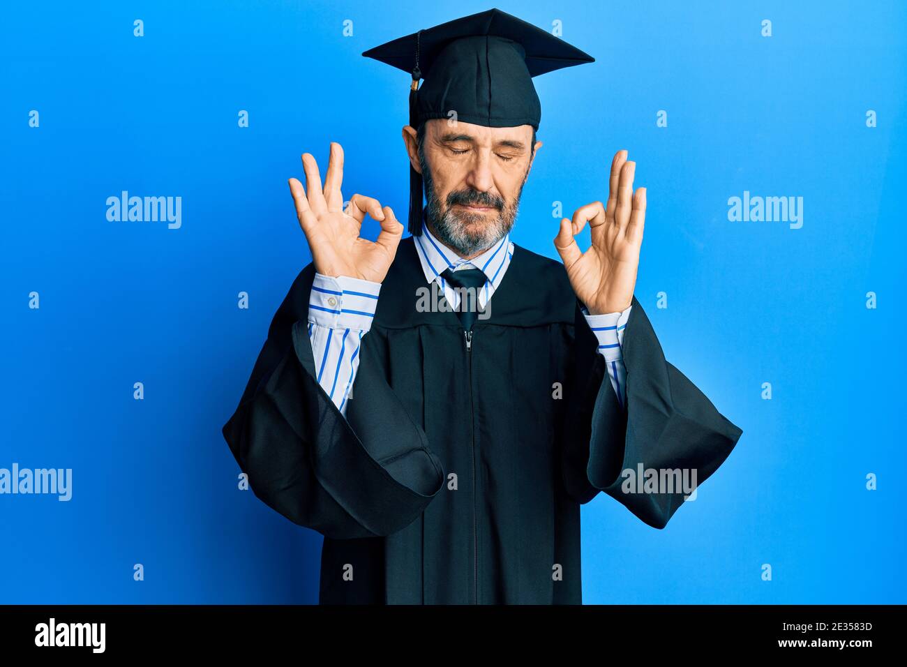 Middle age hispanic man wearing graduation cap and ceremony robe relax ...