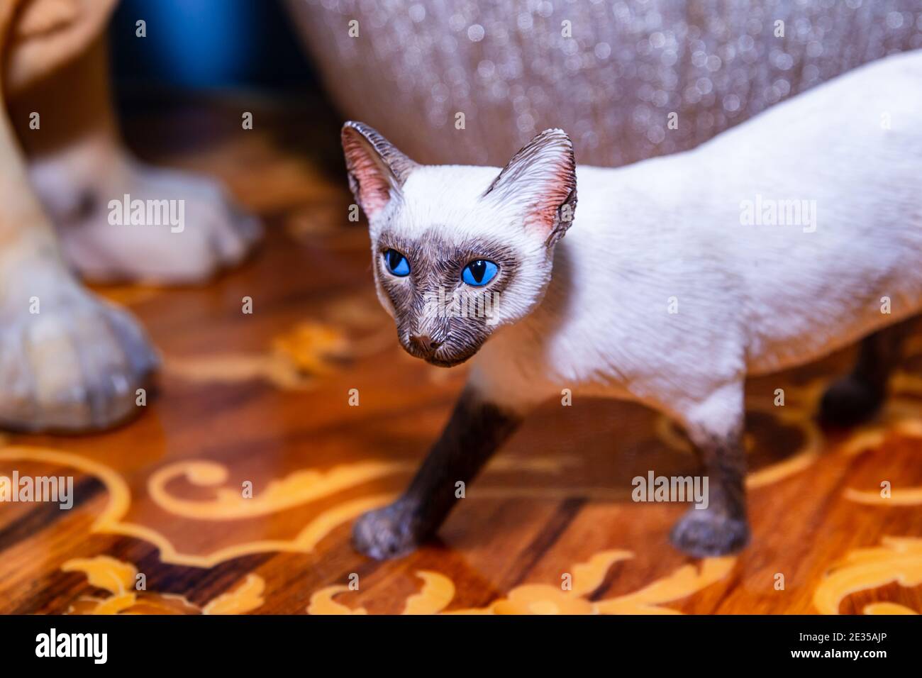 Siamese cat figurine with bright blue eyes Stock Photo
