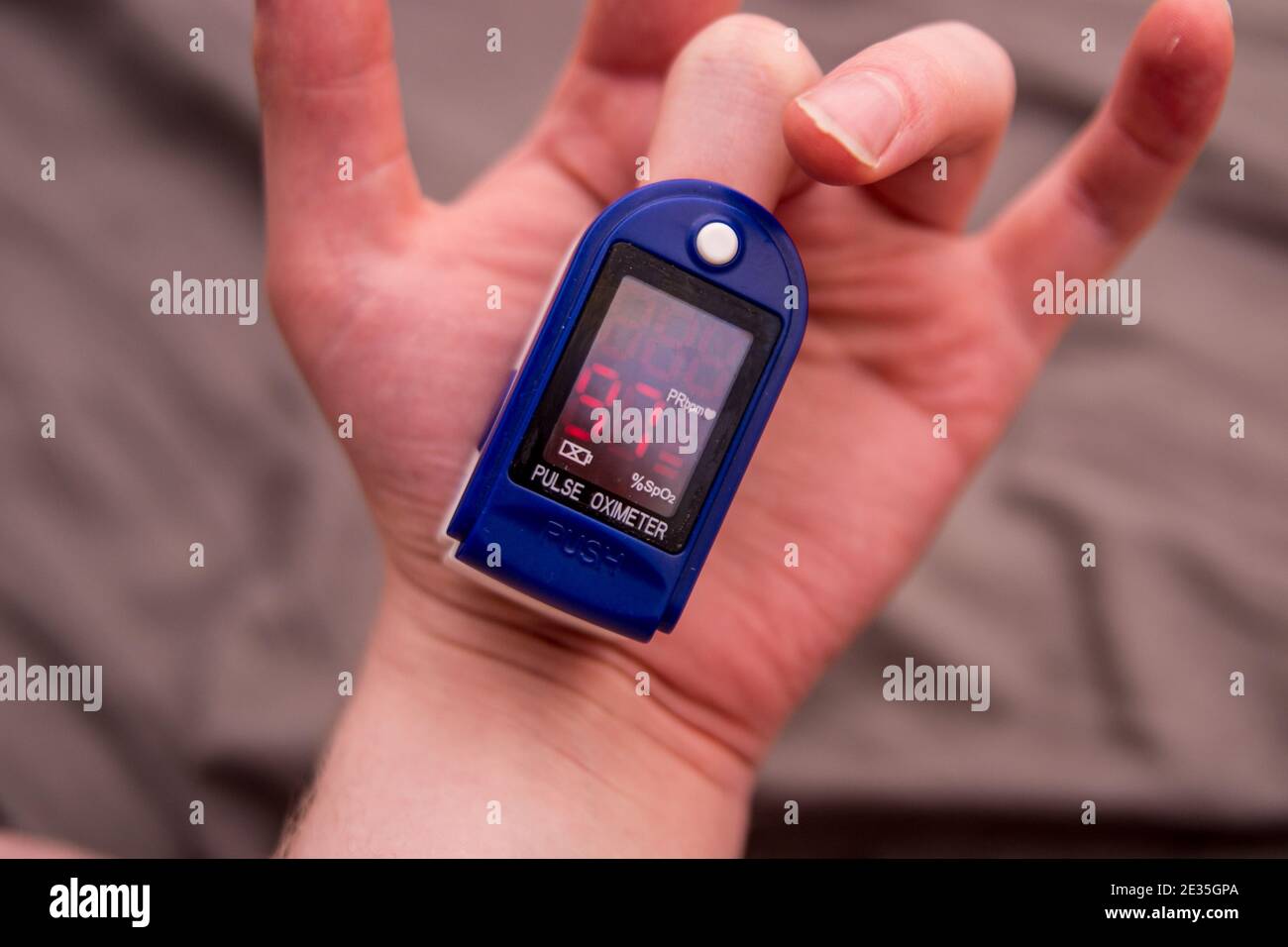 Self-testing with pulse oximeter on white hand Stock Photo