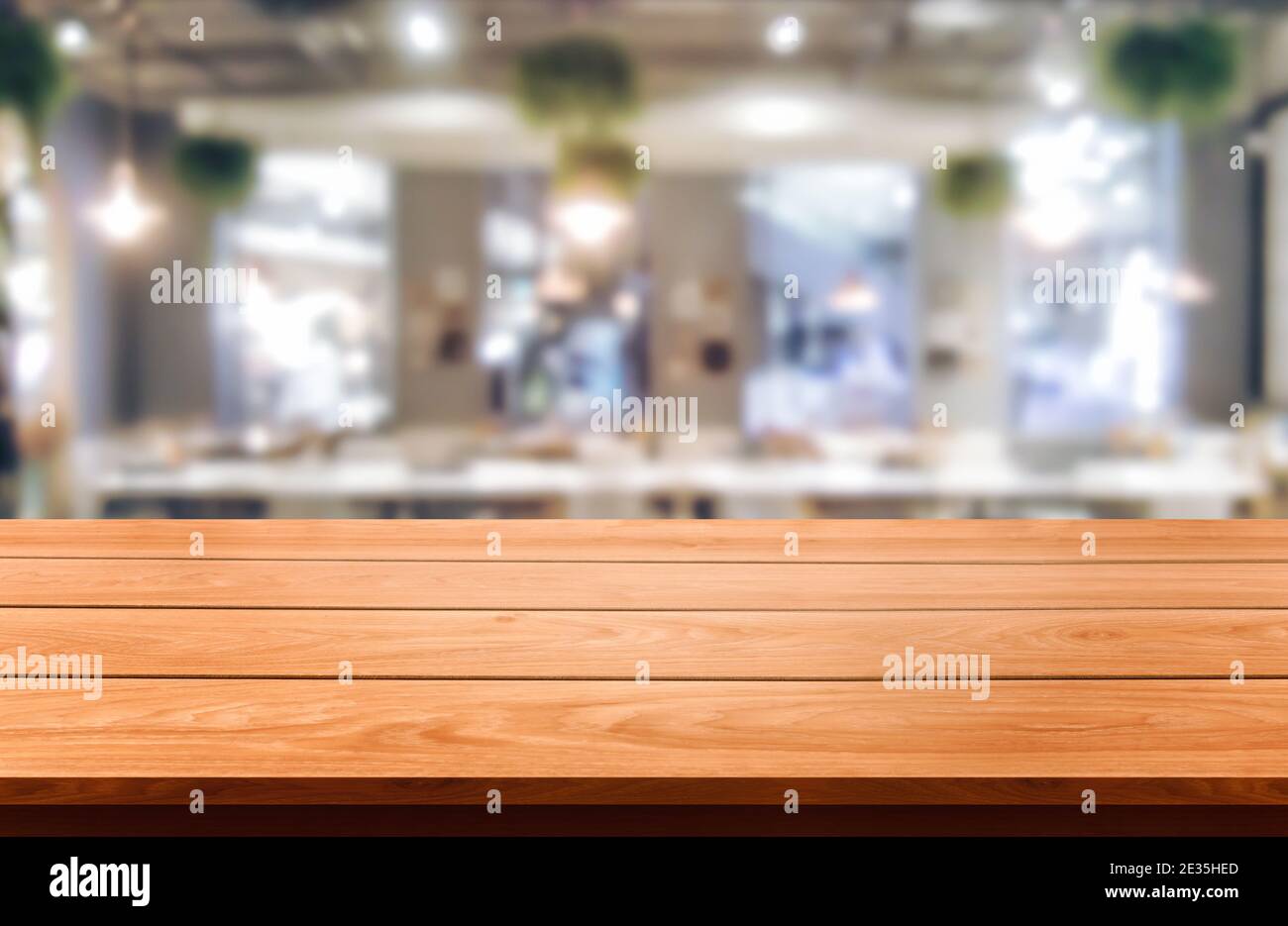 Wood table in blurry background of modern restaurant room or coffee shop with empty copy space on the table for product display mockup. Interior Stock Photo