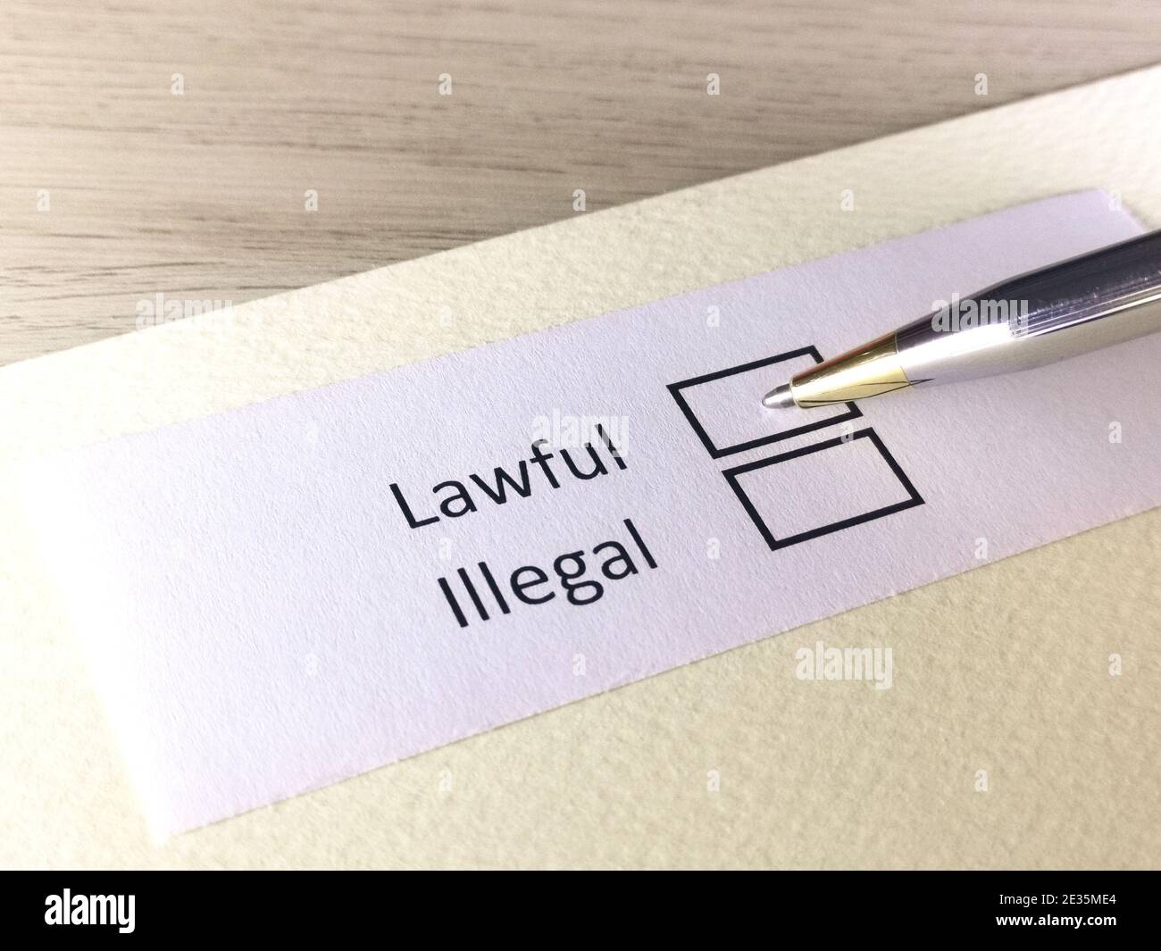 One person is answering question on a piece of paper. The person is thinking to be lawful or illegal. Stock Photo