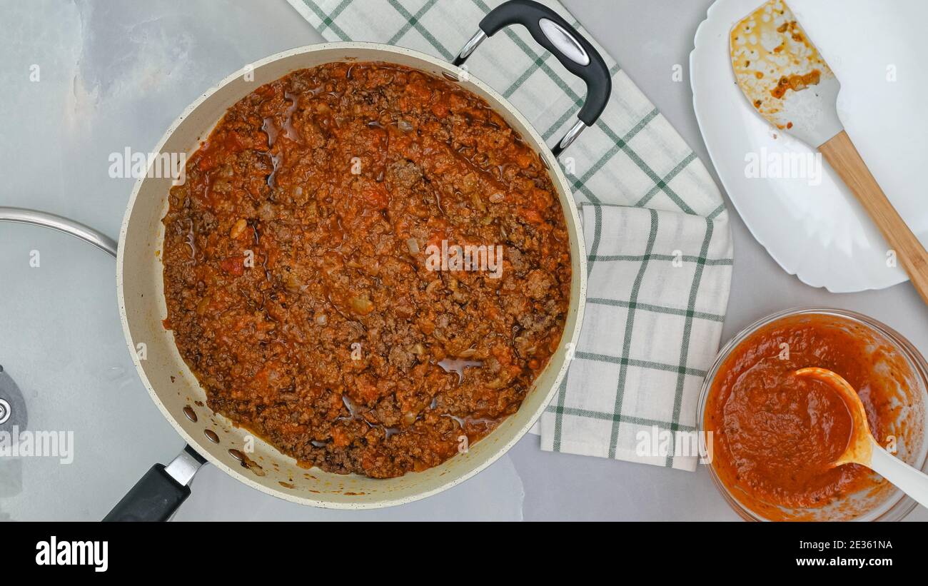 Ground beef fried with spices and marinara sauce close up on frying pan