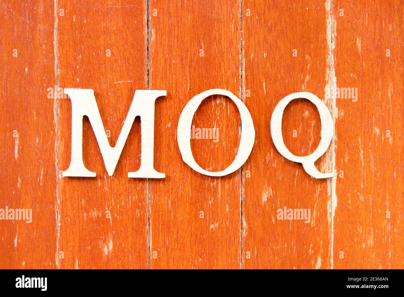 Alphabet letter in word MOQ (Abbreviation of Minimum Order Quantity) on old red color wood plate