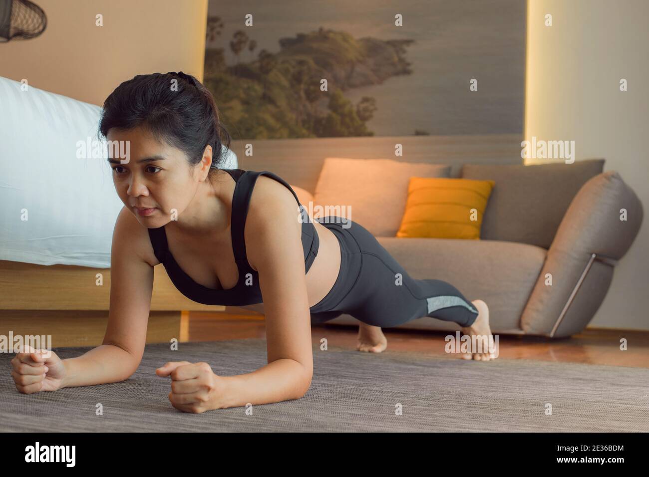 Woman practice yoga Plank pose to meditation in bedroom after wake up in the morning. Healthy and sport lifestyle. Stock Photo