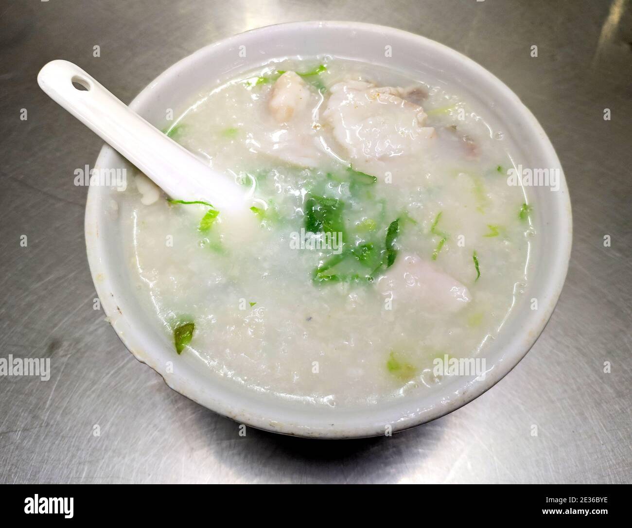 fresh rice porridge with fish meat and green vegetables in the bowl for