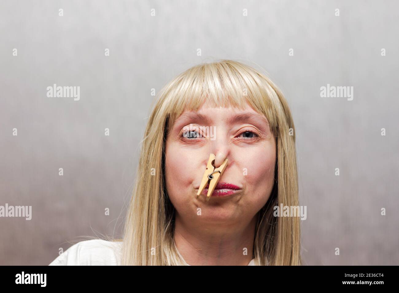 The woman covered her nose with a clothespin. The staged photo seems to