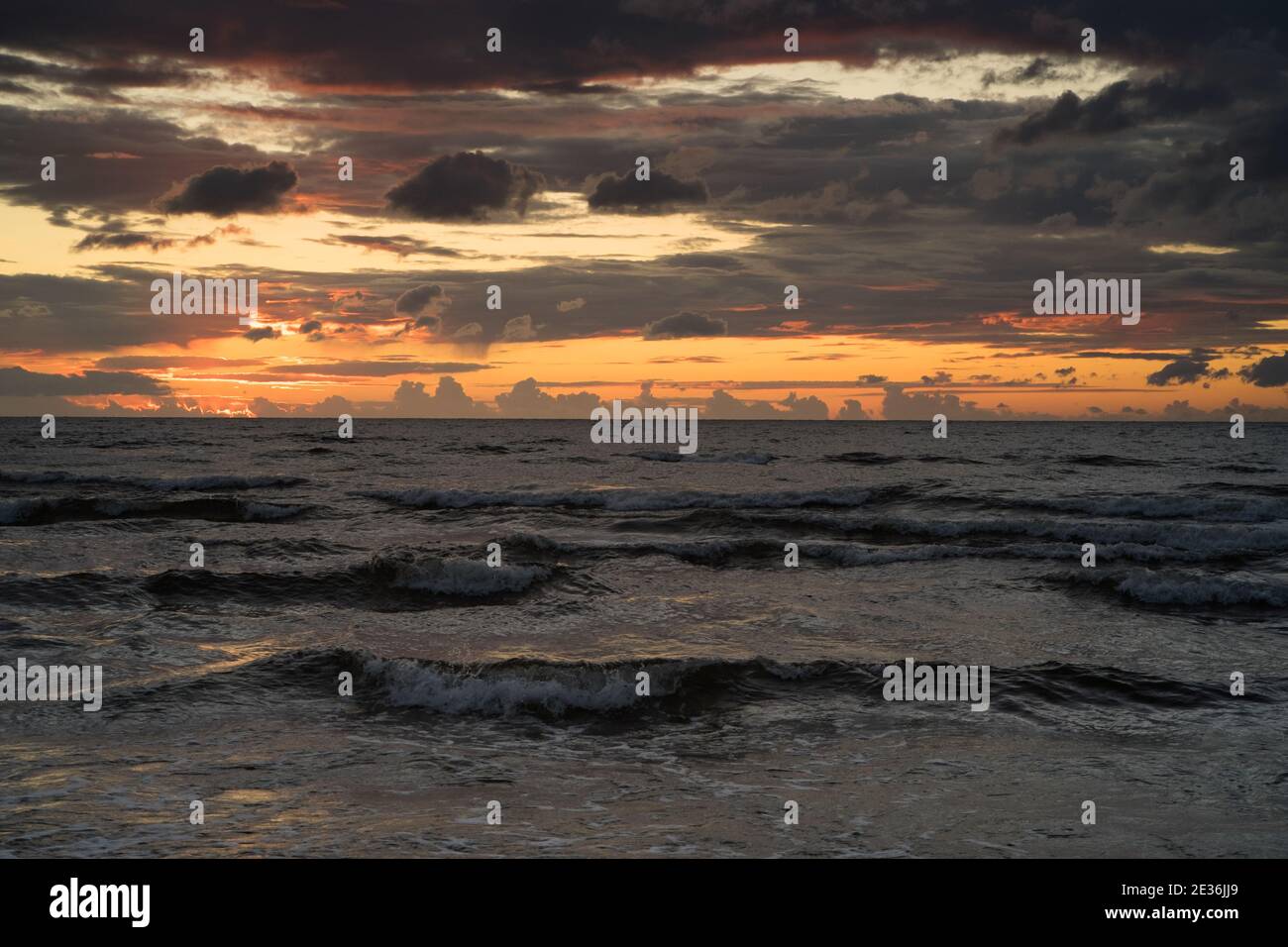 Dark waves and after sunset light in the dark clouds on baltic coast Stock Photo