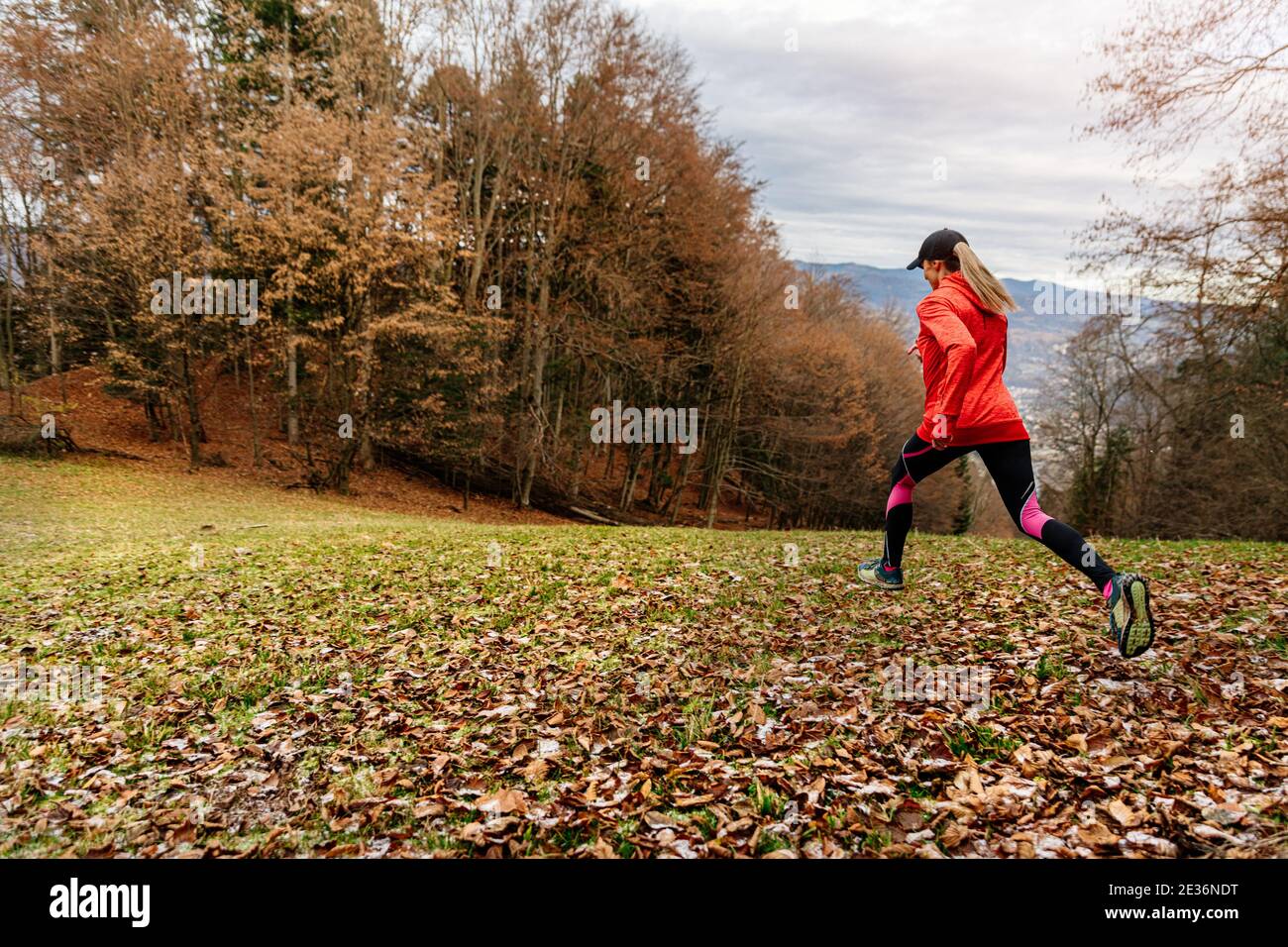 Healthy woman in red sweatshirt running on mountain trail in autumn ...