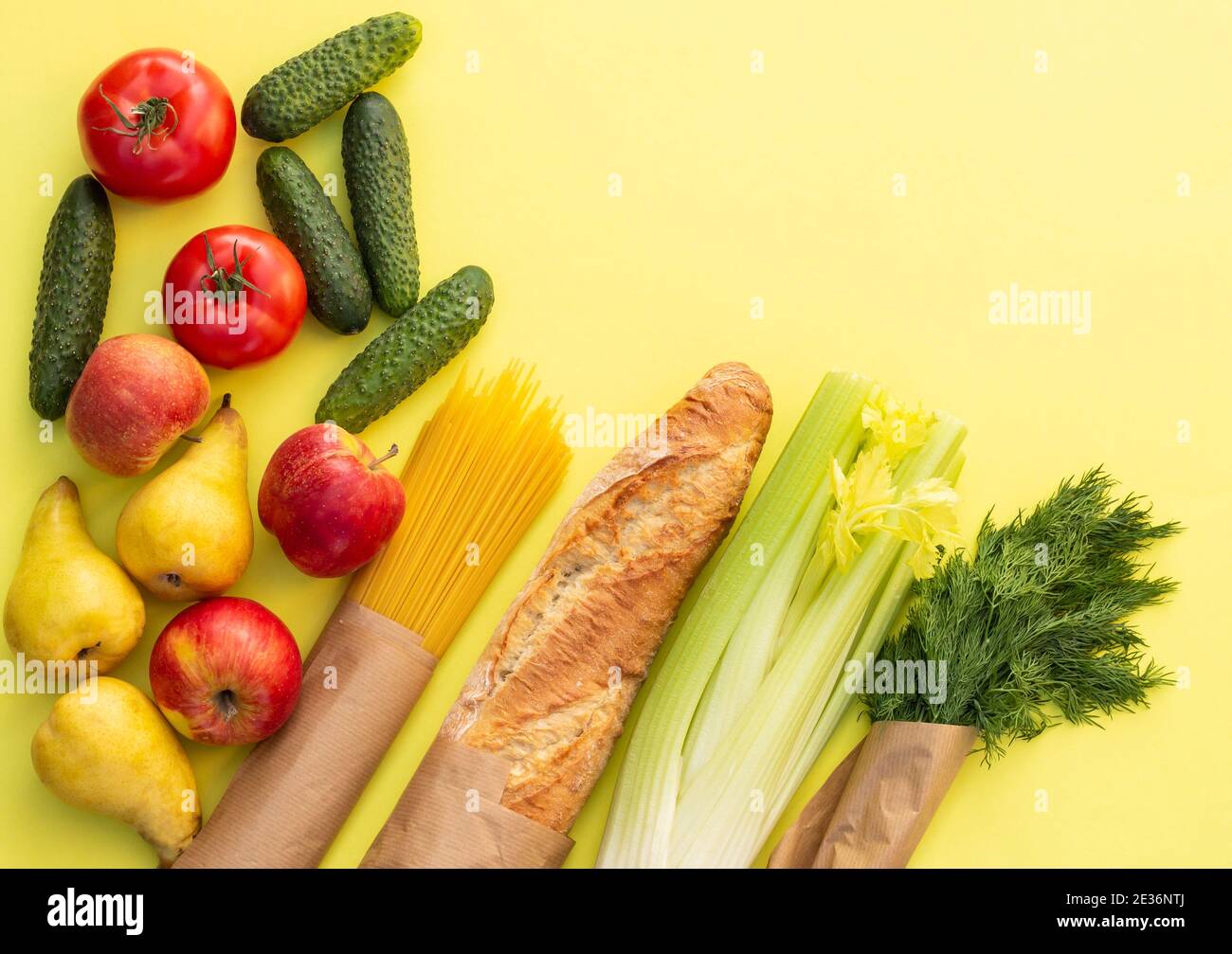 Fresh organic bread, vegetables, greens and fruits, cereals and pasta on a yellow background. Ecological farm food concept. Top view. Flat lay Stock Photo