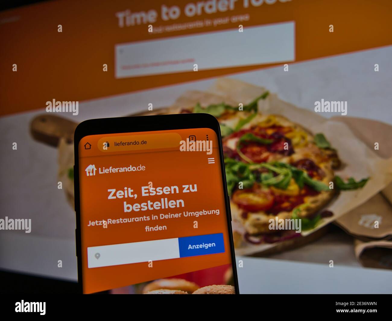 Website of online food delivery company Lieferando.de displayed on smartphone. Text: Time to order food. Find restaurants in your area. Stock Photo