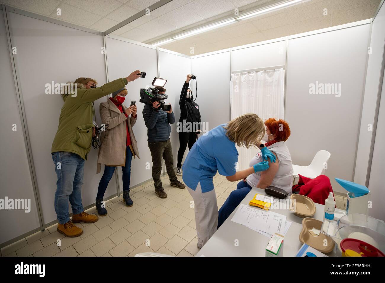 Pirna, Germany. 12th Jan, 2021. Sister Anne Schüring (centre)) giving the Covid-19 vaccine from Biontech and Pfizer to Grit Debler (r), Johanniter employee, at the press event. The vaccination centre of the Sächsische Schweiz-Osterzgebirge district is located in the former Aldi discount store. Here, people of advanced age and from the health care system from the district will be vaccinated from 11.01.2021. Credit: Daniel Schäfer/dpa-Zentralbild/dpa/Alamy Live News Stock Photo