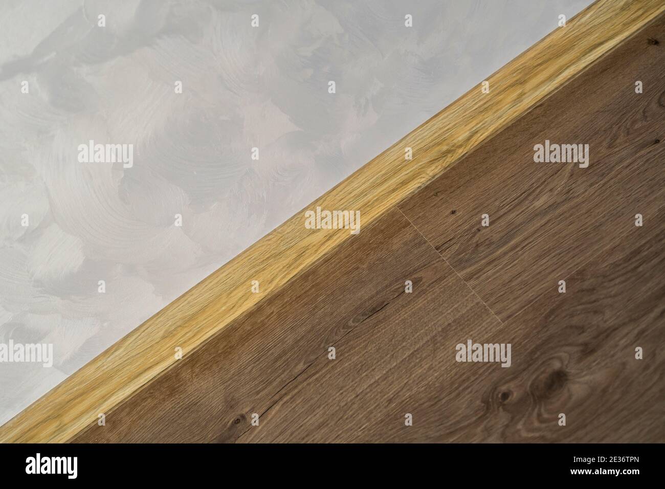 Laminate with plastic baseboard with a wooden texture. Newly installed