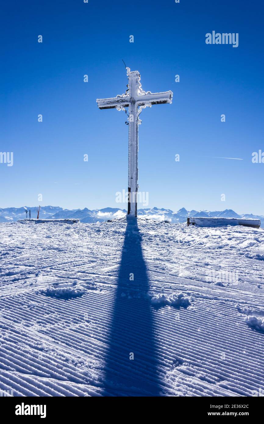 Rossbrand mountain crucifix in the Austrian alps covered in ice, backlit by the sun Stock Photo