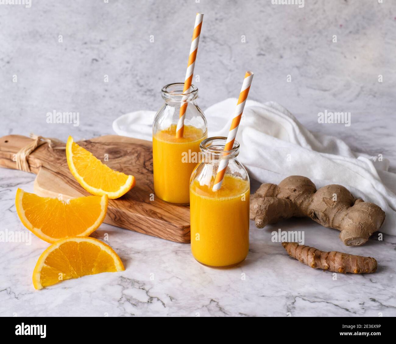 Two identical bottles filled with homemade ginger turmeric orange shot