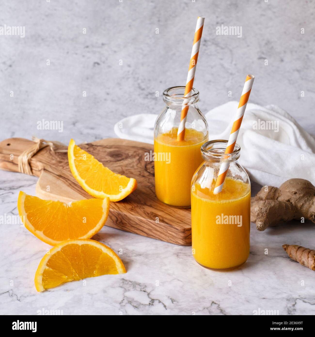 Two identical bottles filled with homemade ginger turmeric orange shot