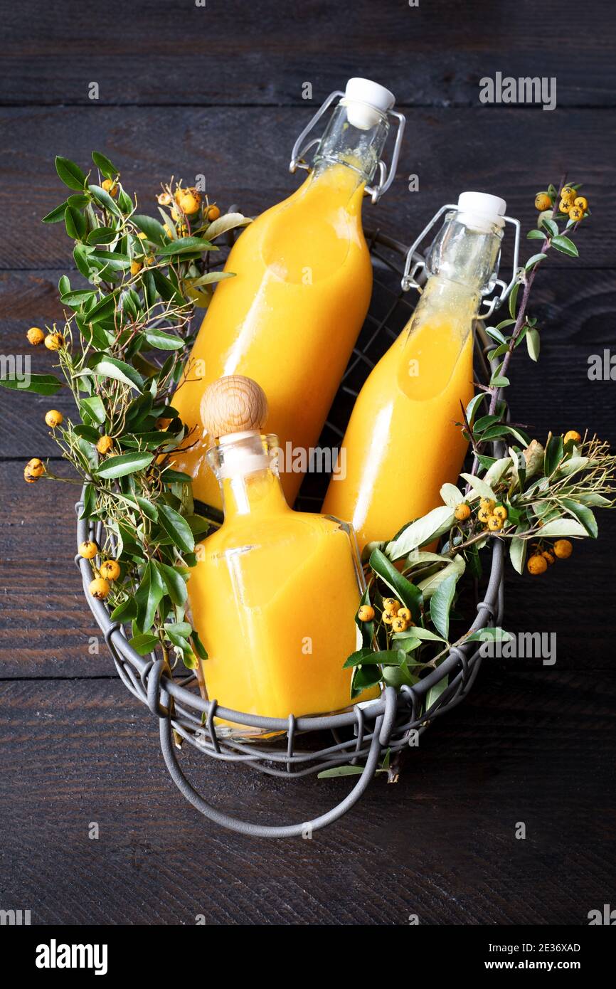 Three bottles filled with ginger turmeric orange shot, a vitamin
