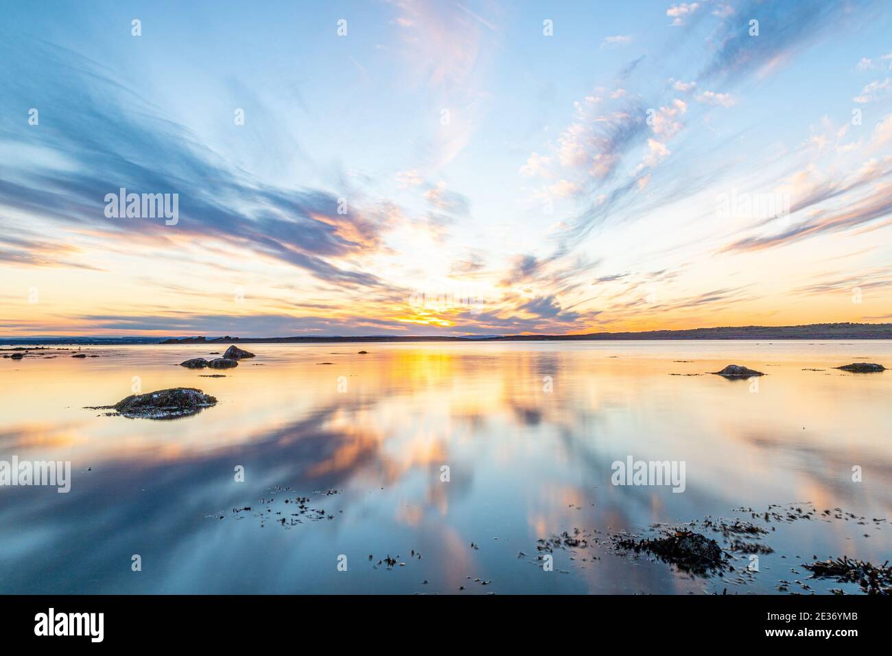 Sunrise sky reflection over a sea. Amazing cloudy sunset over the sea ...