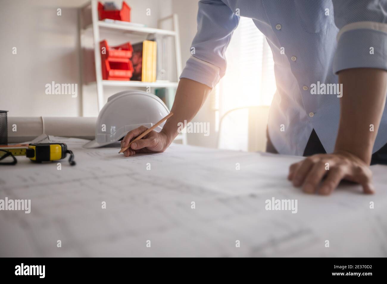 Architect working in office with blueprints,engineer thinking and planning inspection in workplace for architectural plan,sketching a construction pro Stock Photo
