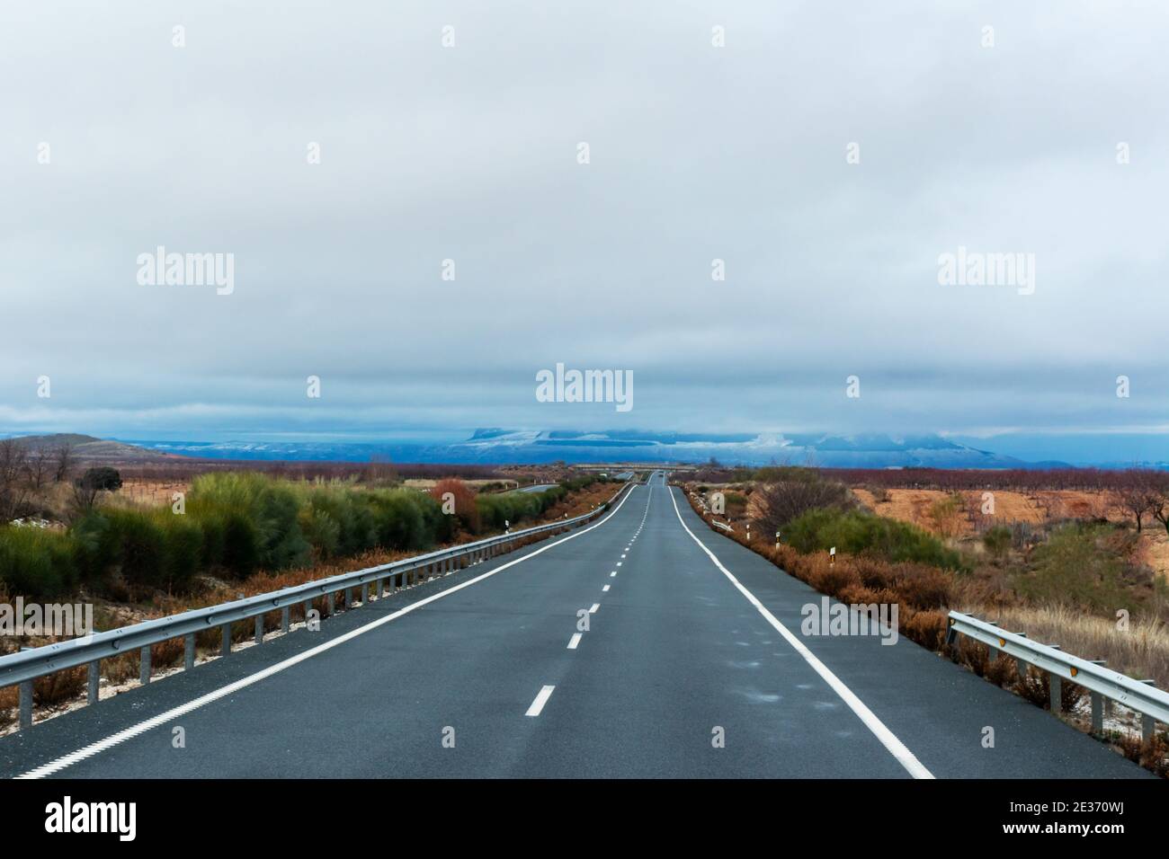Straight road lost in the horizon on a cloudy day. Stock Photo