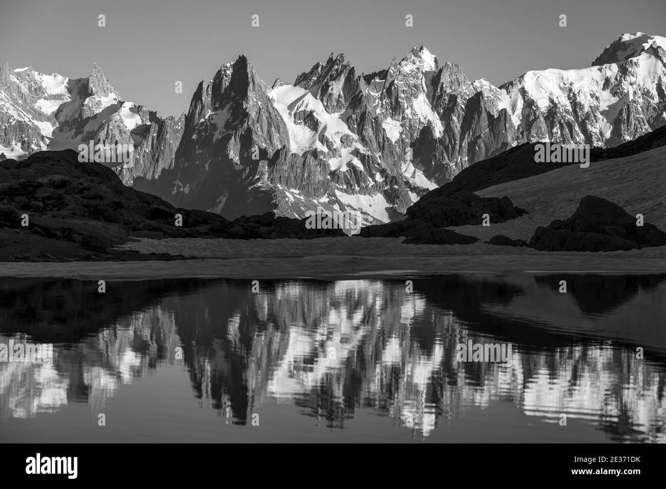 Black and white, mountain panorama with water reflection in Lac Blanc, mountain peaks, Grandes Jorasses and Mont Blanc massif, Chamonix-Mont-Blanc Stock Photo