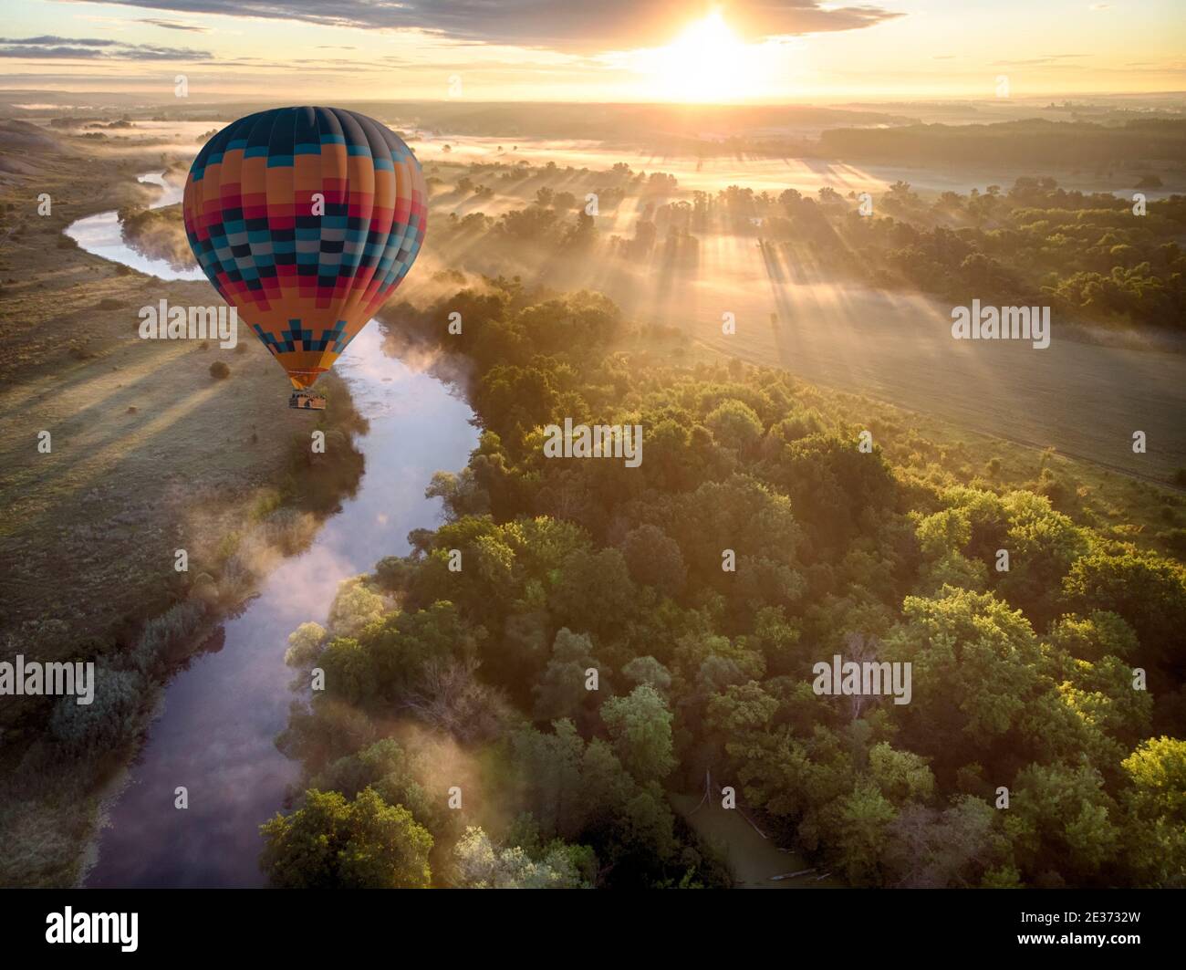 Hot air balloon over river on sunset. Travel, freedom, adventure, exploration, extreme concept. Stock Photo