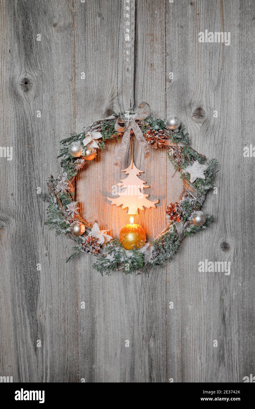 Christmas wreath on wooden wall with candle Stock Photo
