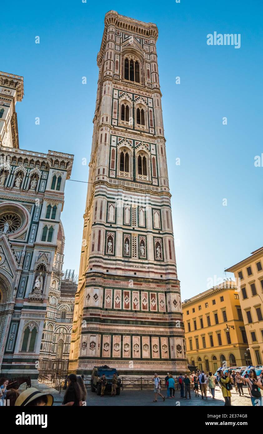 Lovely full view of the famous Giotto's Campanile from the west side with military guards. The free-standing bell tower is part of the Florence... Stock Photo