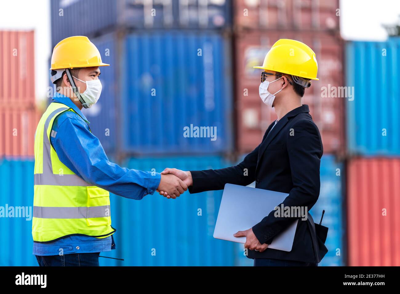 Business handske with Supervisor control loading Containers box from Cargo freight ship for import export. Stock Photo
