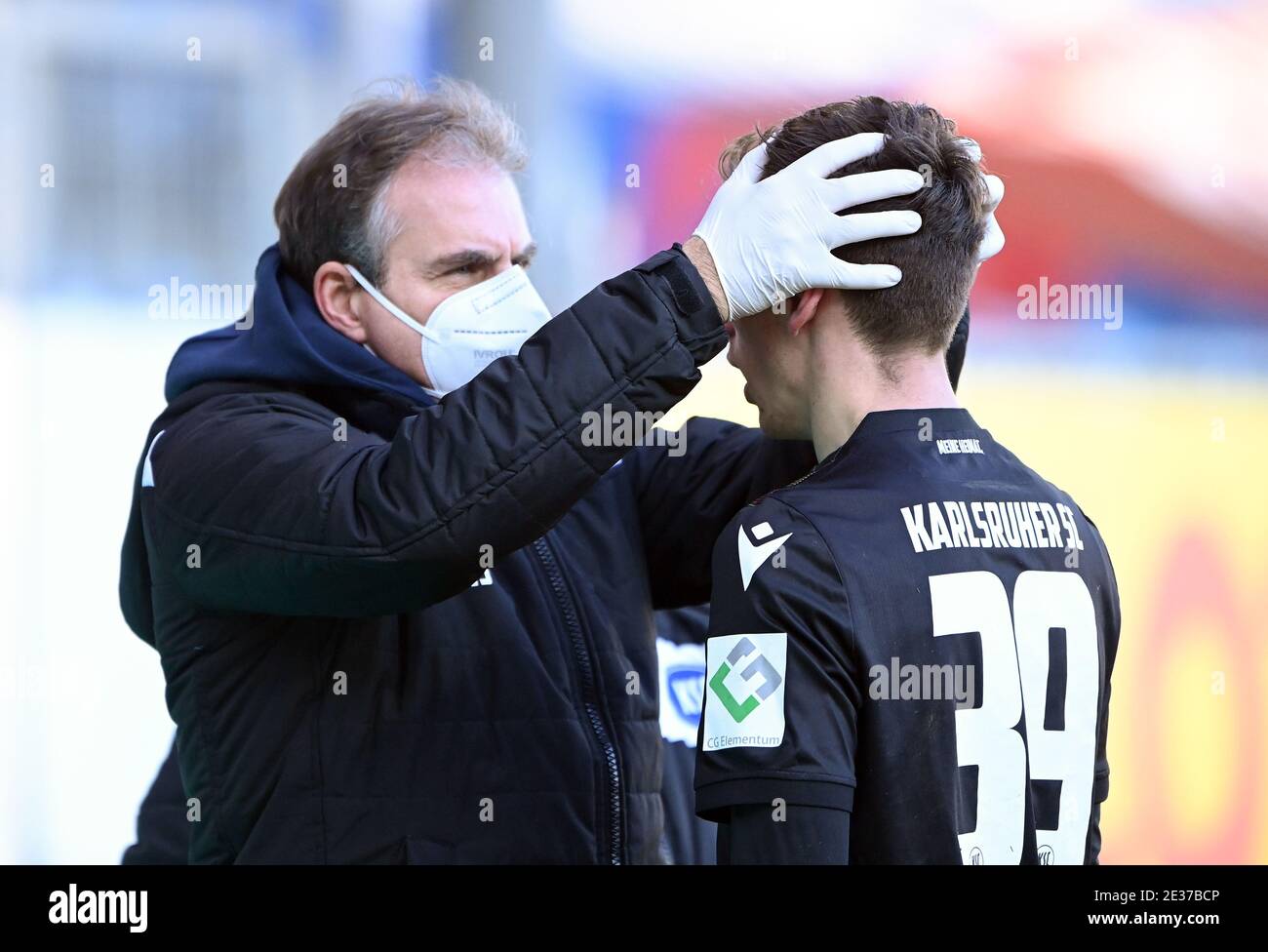 Team doctor Dr. Marcus Schweizer (with protective mask/KSC) examines the head of Benjamin Goller (KSC)/r. GES/Football/2. Bundesliga: Holstein Kiel - Karlsruher Sport-Club, February 17, 2021 Football/Soccer: 2nd League: Holstein Kiel vs. Karlsruher Sport-Club, Kiel, January 17, 2021 | usage worldwide Stock Photo
