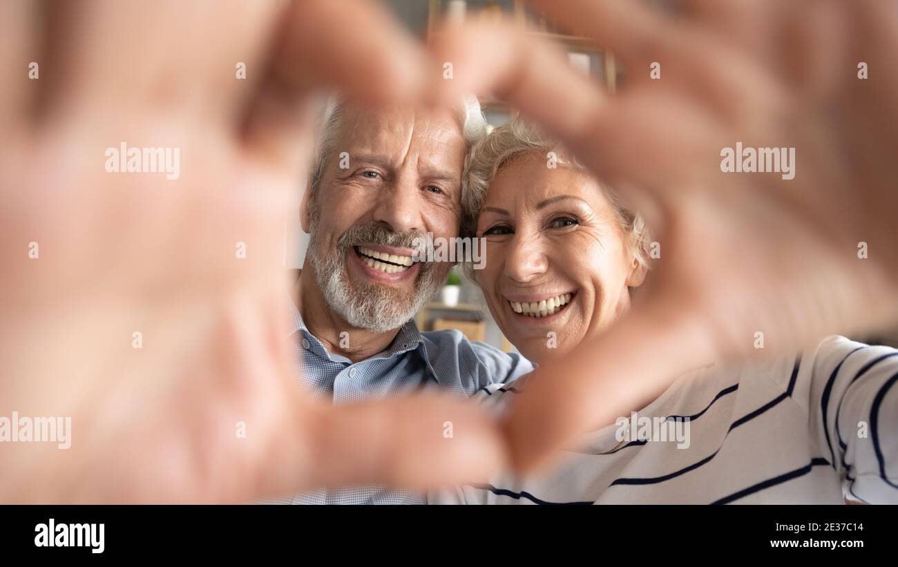 Happy middle aged elderly retired family couple making heart gesture Stock  Photo - Alamy