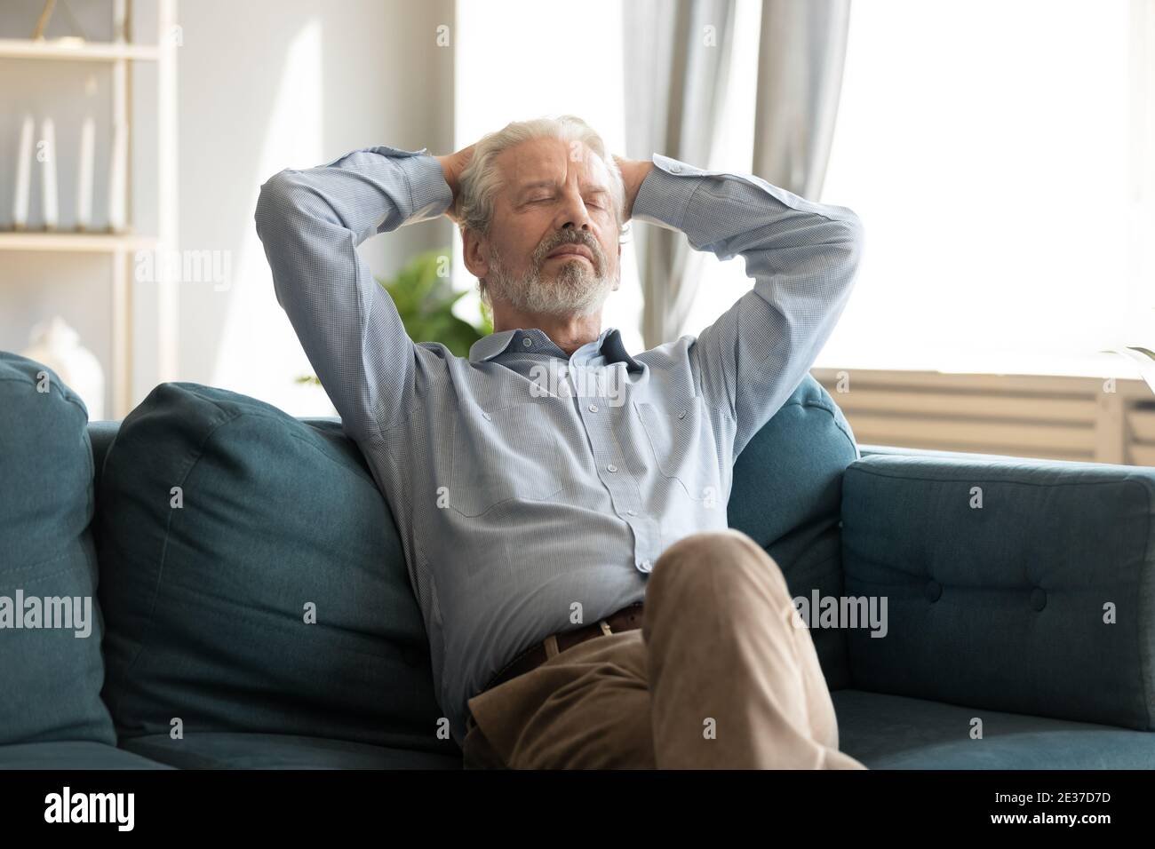 Relaxed smiling middle aged man sleeping on comfortable couch. Stock Photo