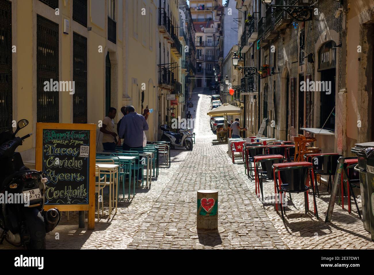 Cobbled street lined with cafes in Alfama, Lisbon, Portugal Stock Photo