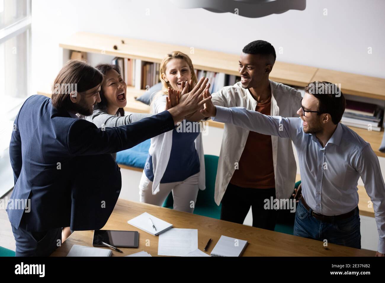 Laughing mixed race teammates giving high five to each other Stock ...