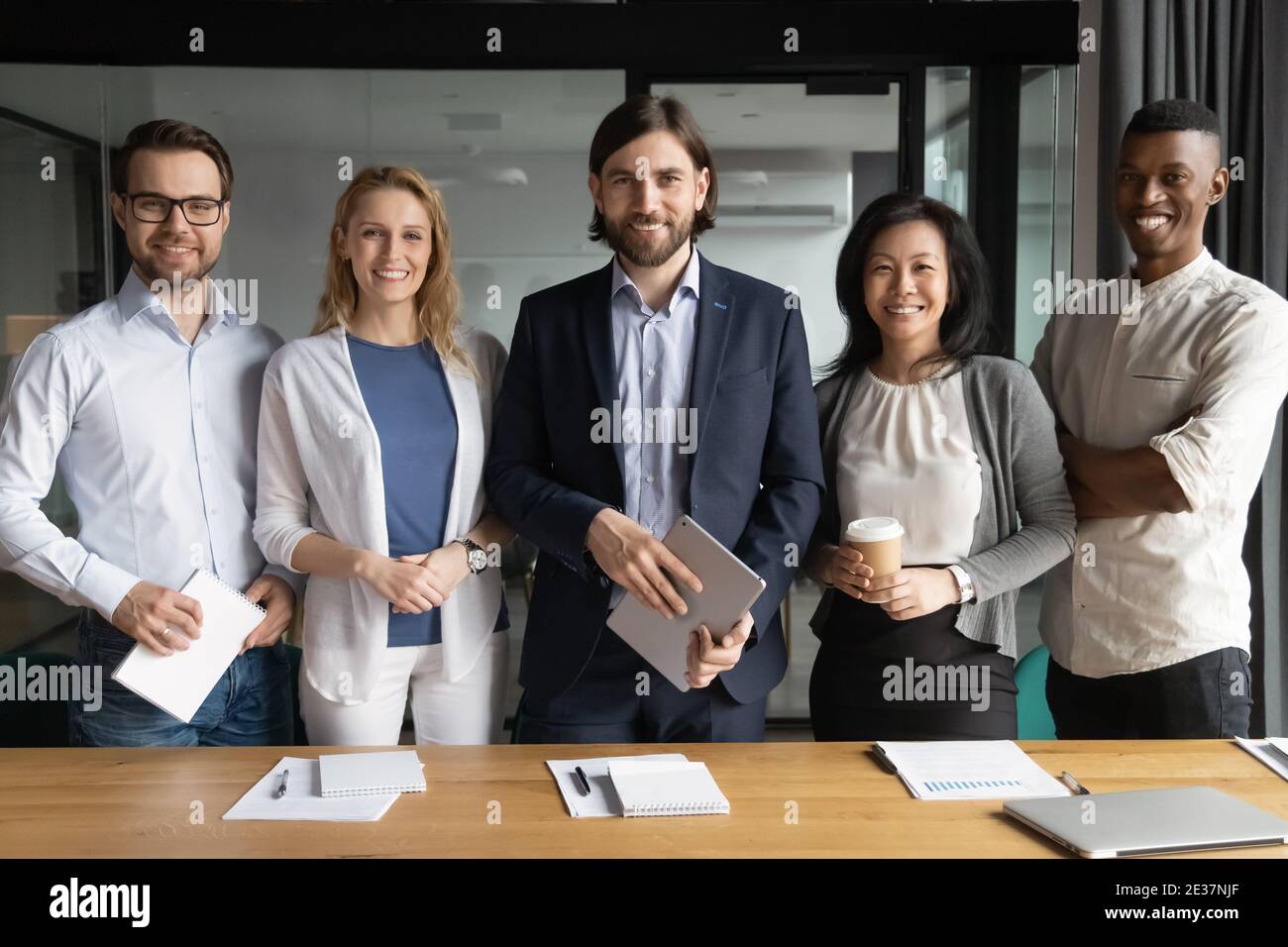 Portrait of smiling confident young and middle aged diverse workers. Stock Photo