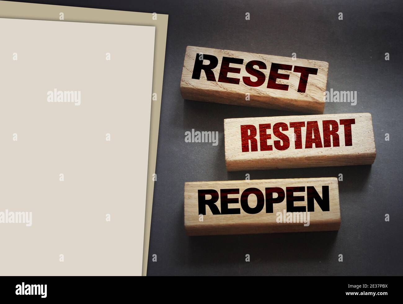 Reset, restart, reopen on wooden blocks on black background. Post pandemic world concept. Stock Photo