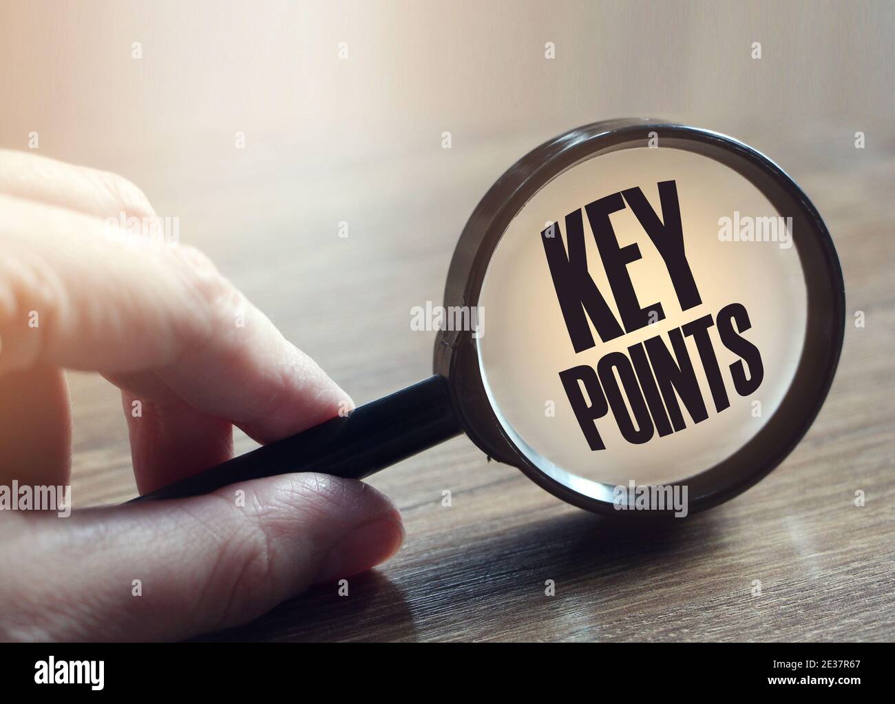 Magnifying glass with text KEY POINTS on wooden table. Stock Photo