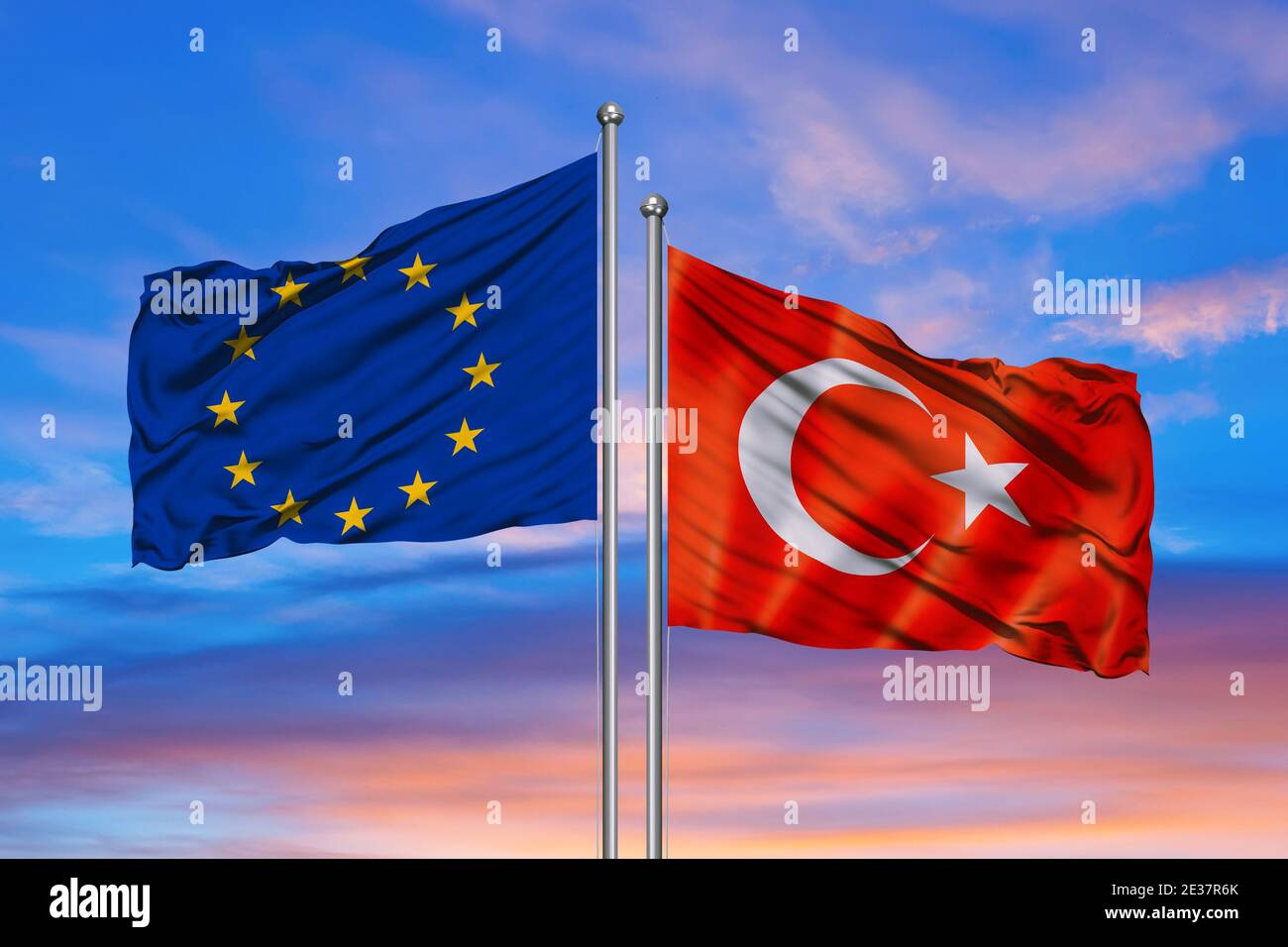 Turkey & European Union Flags are waving in the sky with dark clouds. Stock Photo