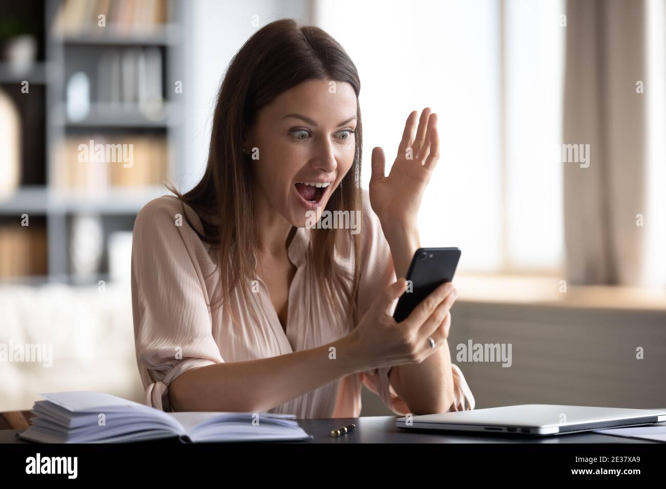 Close up shocked woman looking at phone screen, reading news Stock Photo