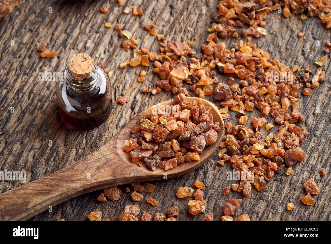 Myrrh resin on a spoon, with Commiphora essential oil in the background Stock Photo