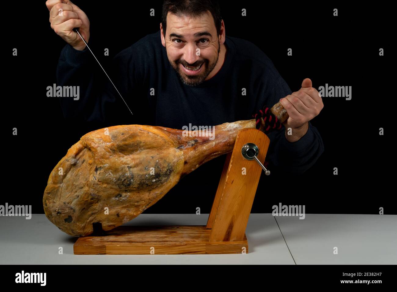 Bearded man with a ham knife ready to cut a piece of typical Spanish ...