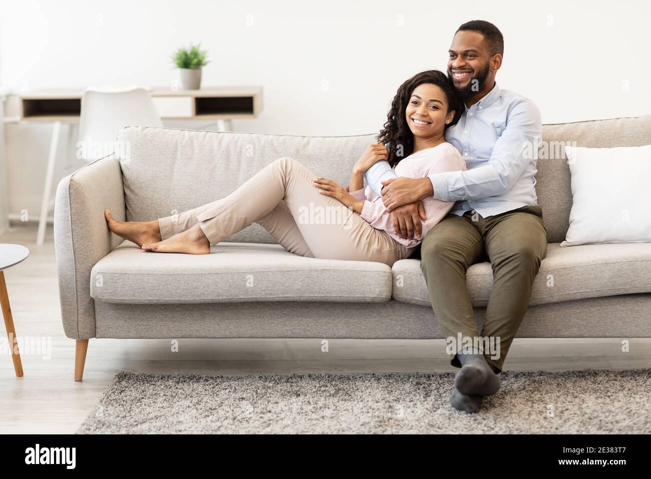 African american couple spending weekend together lying on couch Stock ...
