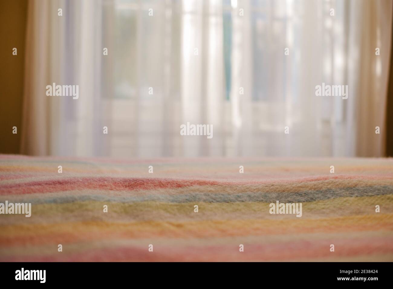 colourful blanket on a bed, with sunlight Stock Photo