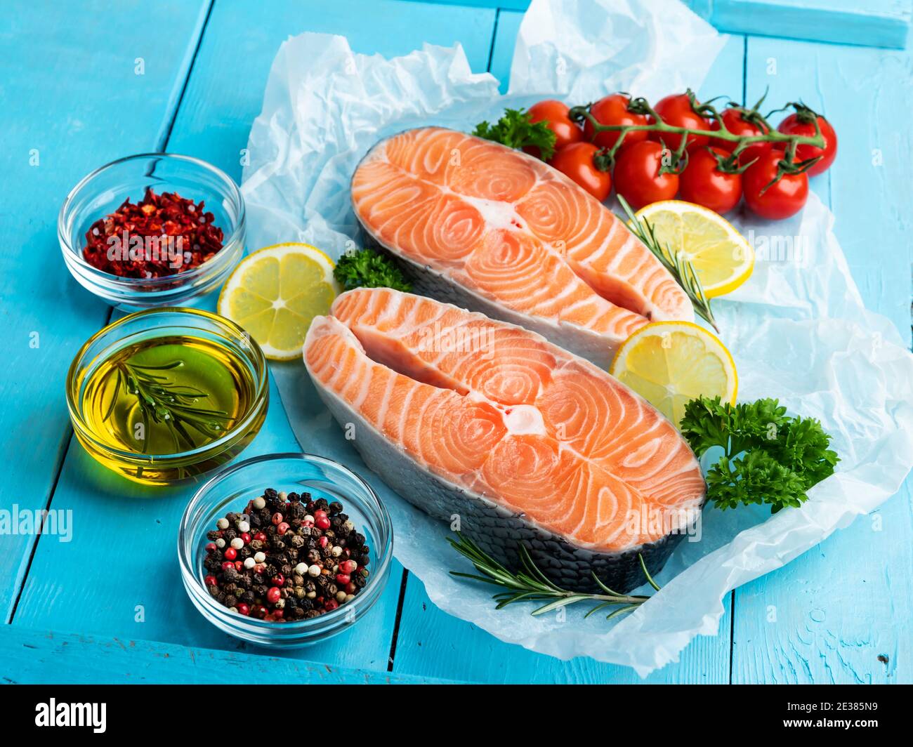 two raw steak fish trout, salmon and spices on a blue wooden background Stock Photo
