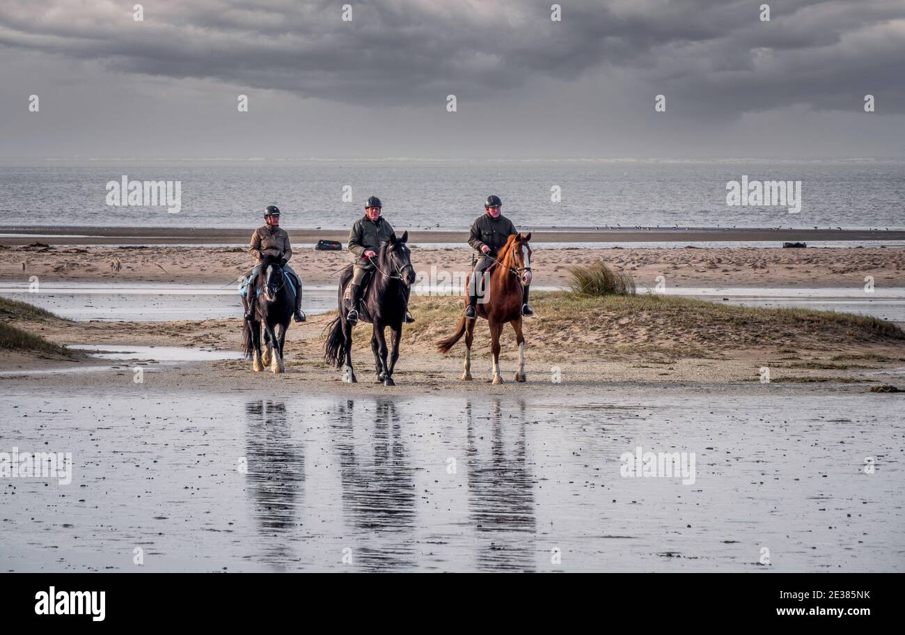Oostvoorne,Holland,17-jan-2021:people riding horse on the beach, many people going outdoor during corona time to get some fresh air Stock Photo