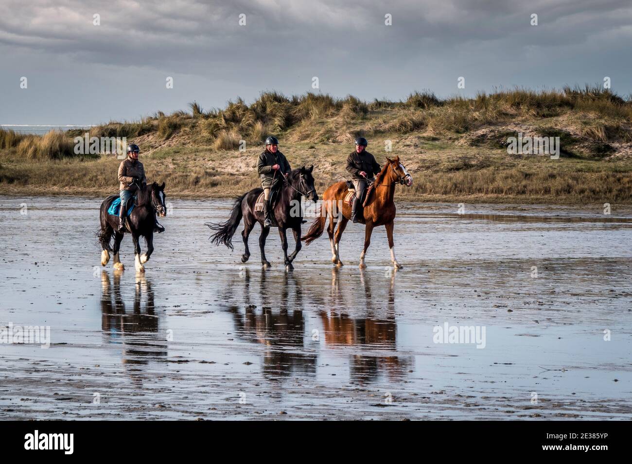 Oostvoorne,Holland,17-jan-2021:people riding horse on the beach, many people going outdoor during corona time to get some fresh air Stock Photo