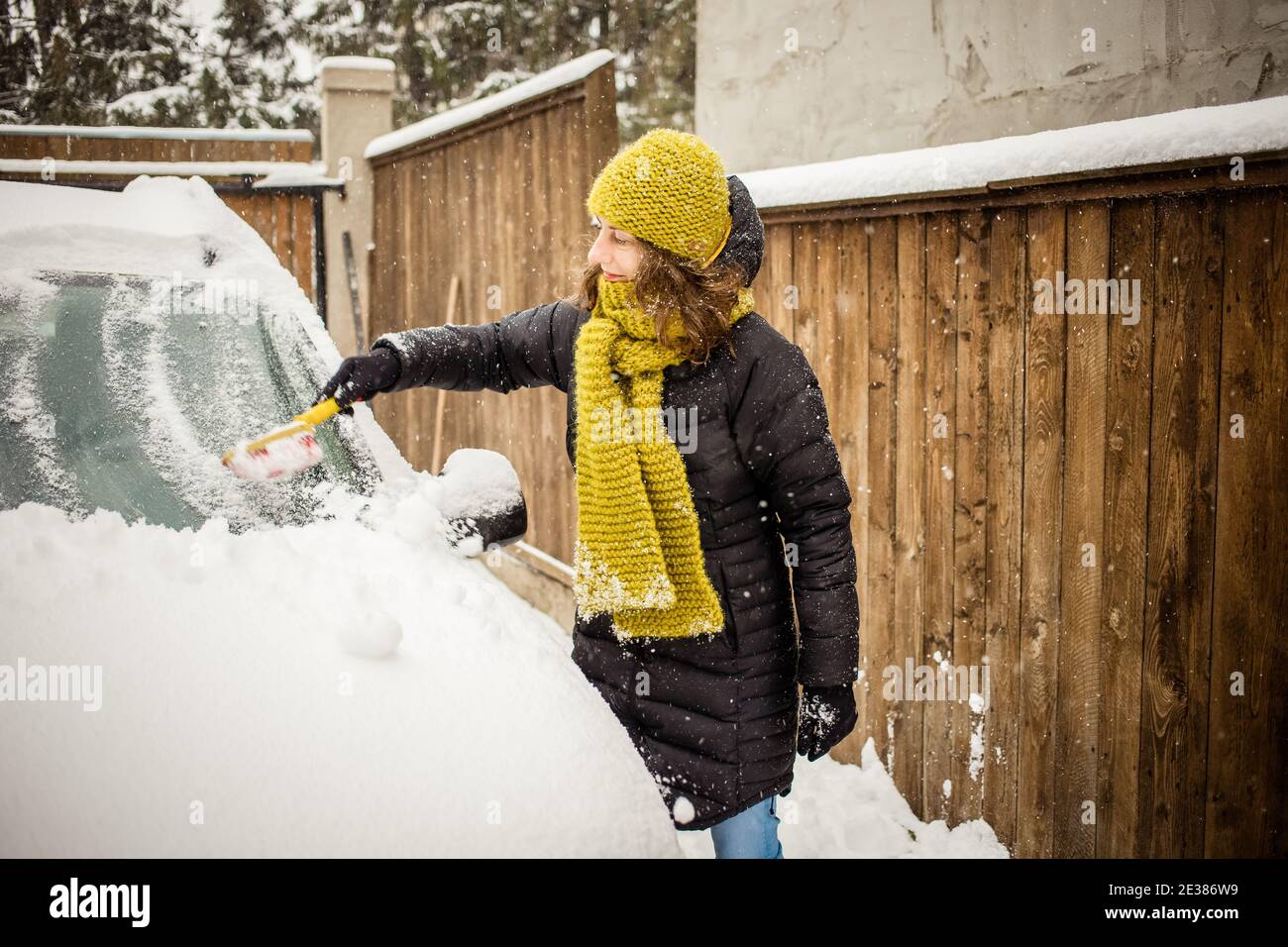 woman cleaning snow from car after blizzard Stock Photo - Alamy
