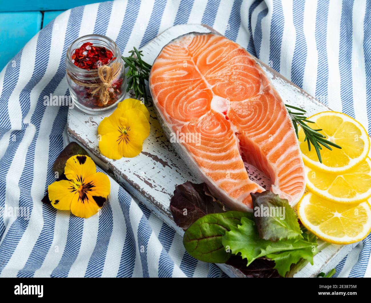 raw steak fish trout, salmon and spices on a blue wooden background Stock Photo