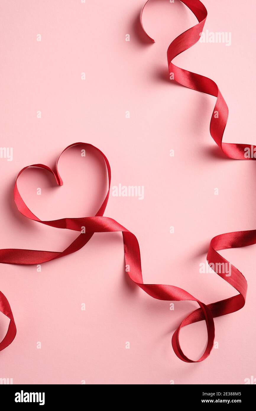 Heart shaped red ribbon on pink background. Love, romance concept.  Valentines Day or Mothers day greeting card template Stock Photo - Alamy